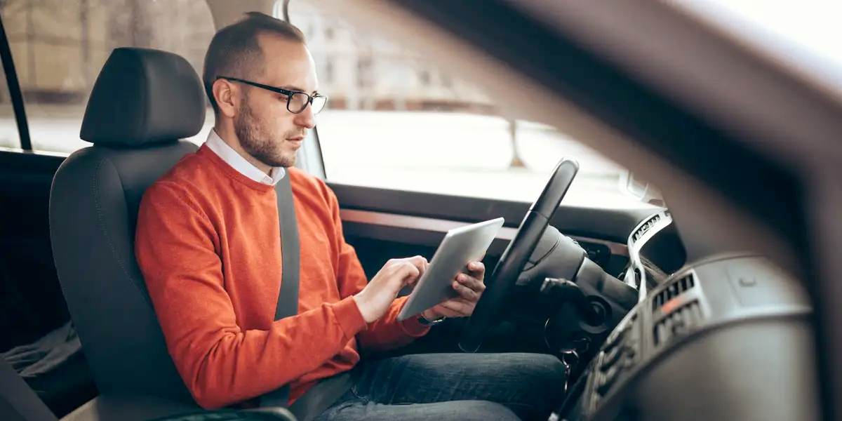 driver looking pleased while comparing insurance rates on a laptop